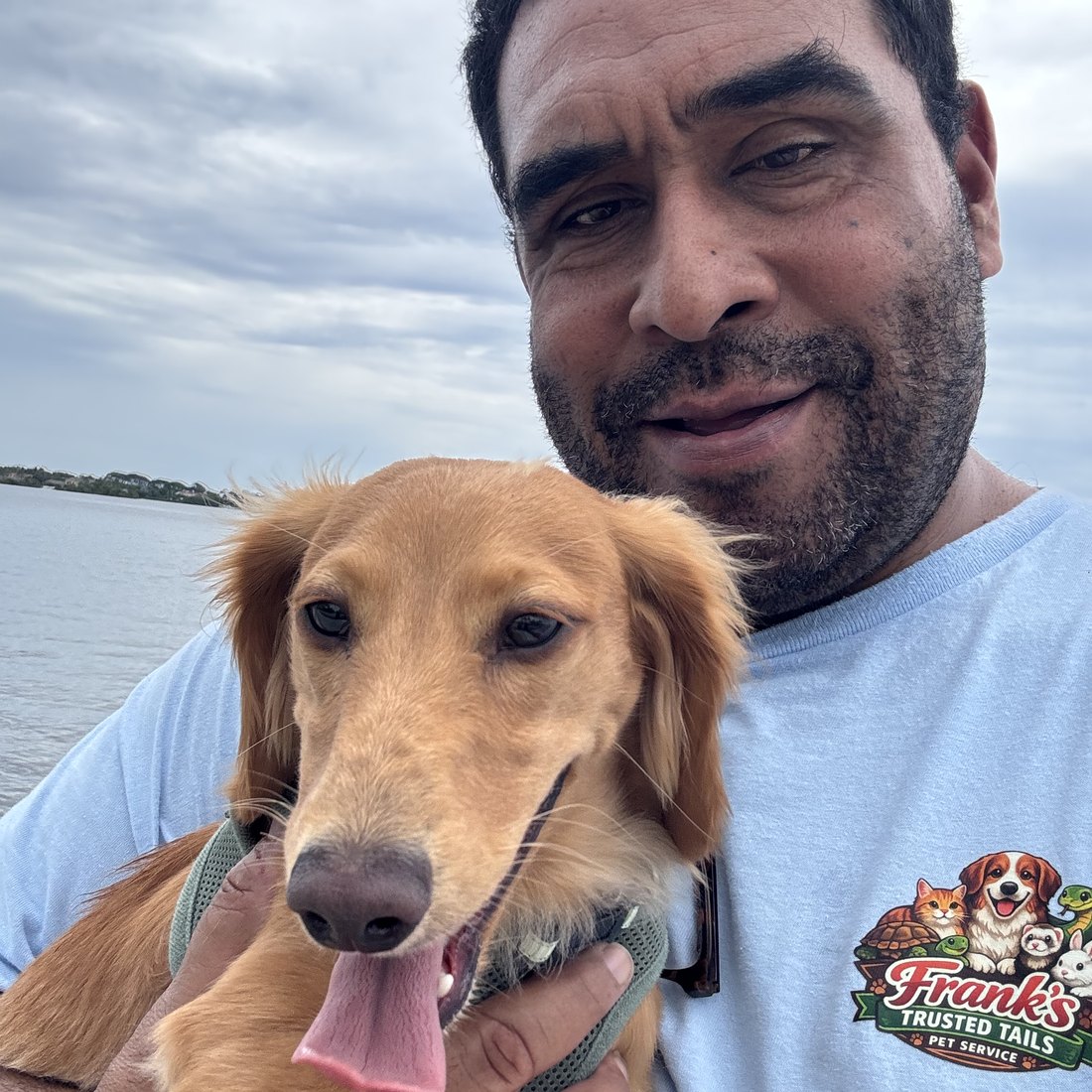 Frank with a happy golden retriever by the water